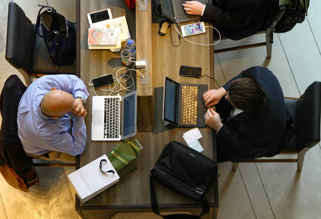 Colegas analisam trabalho e prioridades junto de um computador.