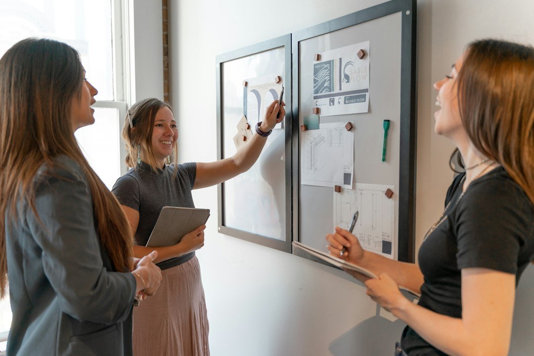 Equipa colabora diante de um quadro de planeamento num ambiente de trabalho saudável.